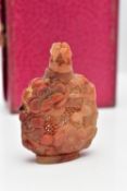 A CARVED CARNELIAN PIERCED BOTTLE, of oriental design with various carved flowers and textured