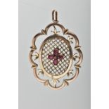 A YELLOW METAL PENDANT, of openwork floral design, with pear cut garnet quatrefoil central panel, to