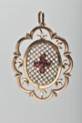 A YELLOW METAL PENDANT, of openwork floral design, with pear cut garnet quatrefoil central panel, to