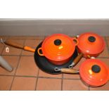 FOUR PIECES OF LE CREUSET CAST IRON COOK WARE, all with orange enamel finish, comprising a twin