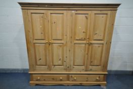 A LARGE PINE FOUR DOOR WARDROBE, with overhanging cornice, and two long drawers, width 204cm x depth