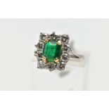 AN 18CT WHITE AND YELLOW GOLD EMERALD AND DIAMOND CLUSTER RING, the rectangular cut emerald,