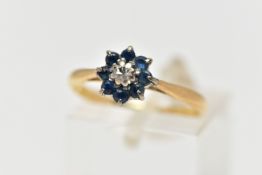 A YELLOW METAL DIAMOND AND SAPPHIRE CLUSTER RING, the brilliant cut diamond centre with circular cut