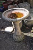 A MODERN COMPOSITE BIRD BATH on fluted and foliate detailed column base and a foliated detailed bowl