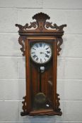 A STAINED OAK WALL CLOCK, the 7 inch enamel dial, with roman numerals, with a pendulum, height 92cm