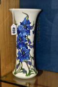 A BOXED MOORCROFT POTTERY DELPHINIUM VASE, of cylindrical tapering form, tube lined with blue