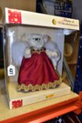 A WHITE STEIFF TEDDY BEAR CHRISTMAS TREE TOPPER, with white feather angel wings, wearing a red