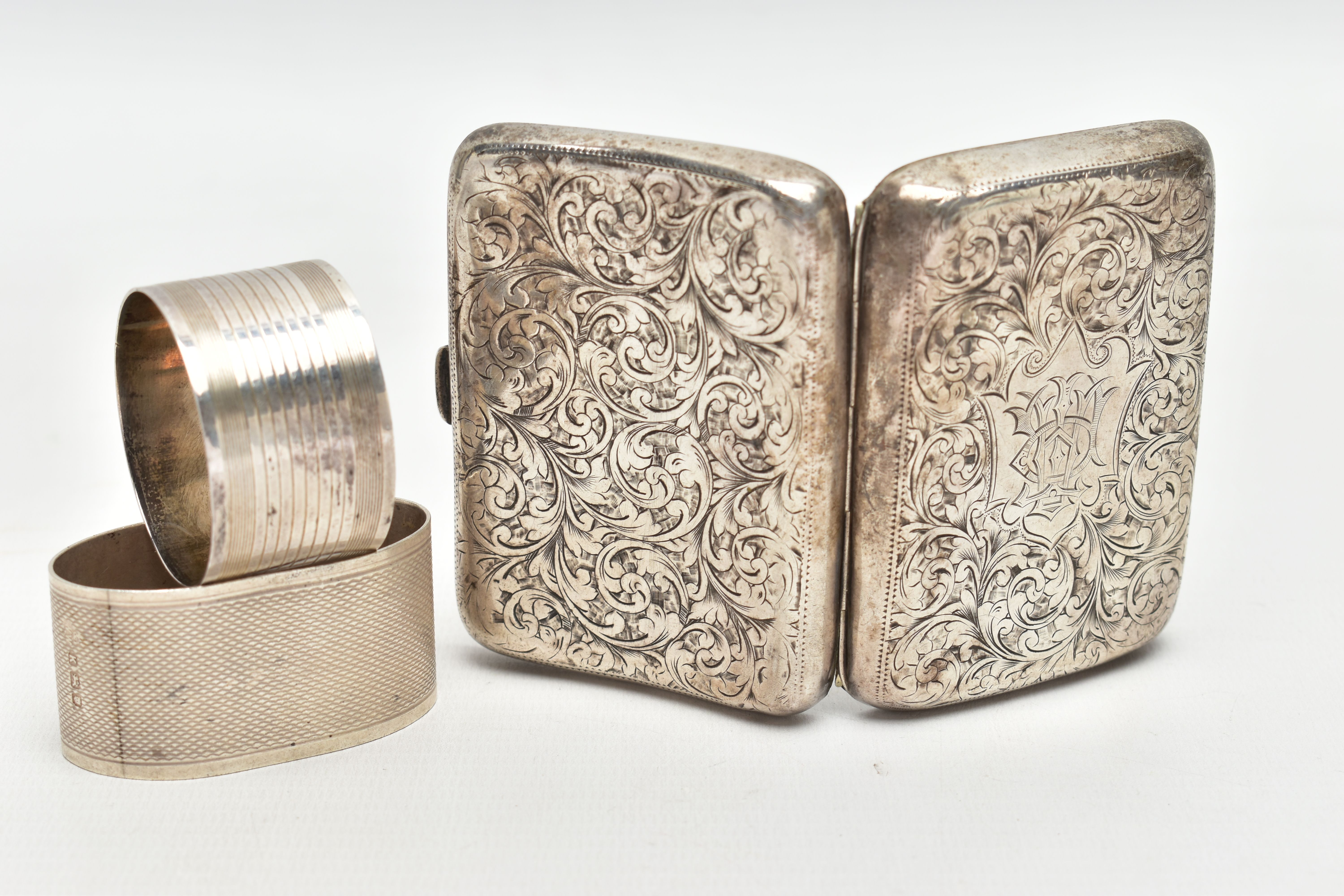 A SILVER CIGARETTE CASE AND TWO NAPKIN RINGS, a rectangular form case, foliage engraving detail,