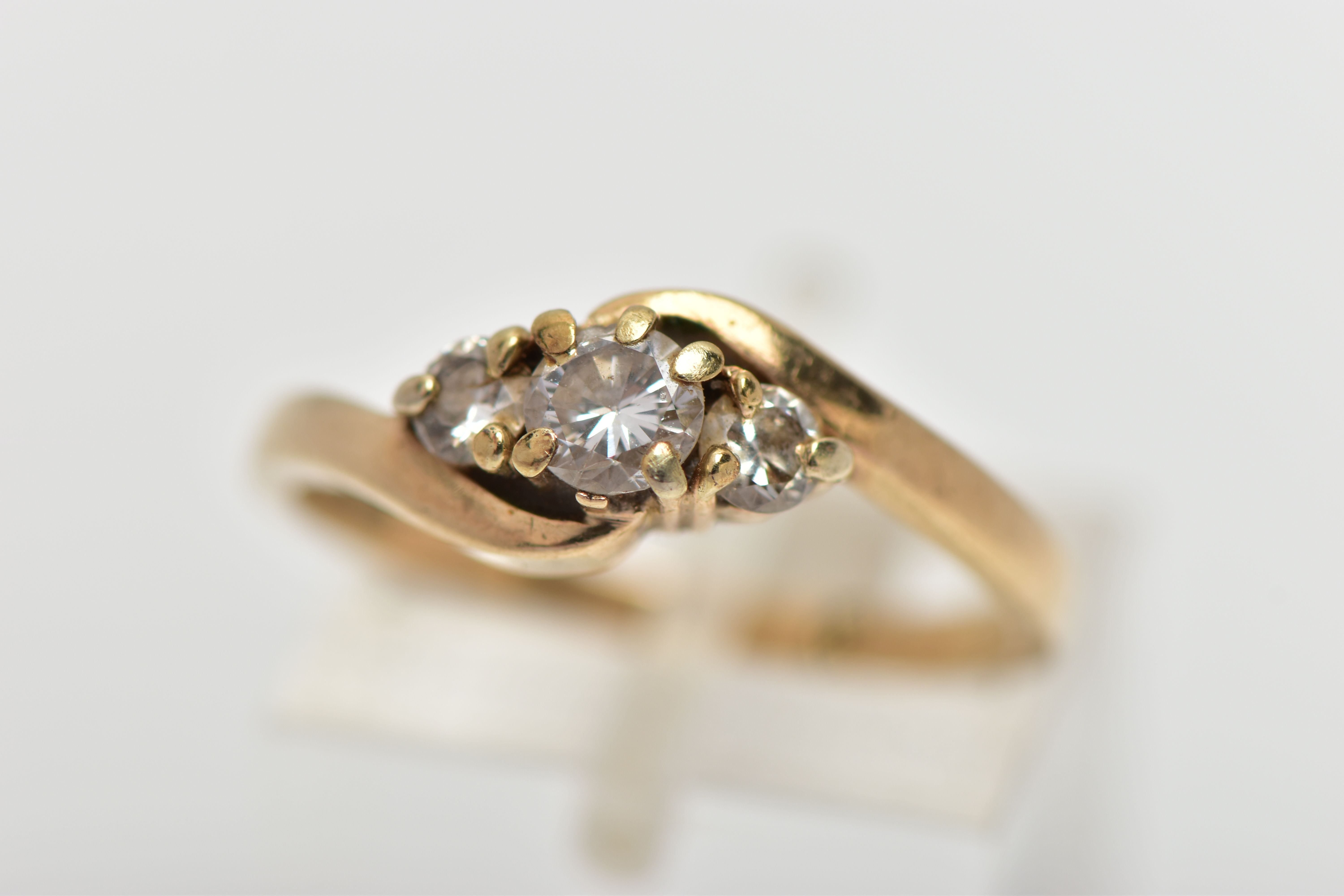 A 9CT GOLD DIAMOND THREE STONE RING, comprising three graduated brilliant cut diamonds, to the