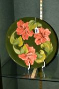 A MOORCROFT POTTERY CHARGER, with coral hibiscus pattern on a green ground, limited edition numbered