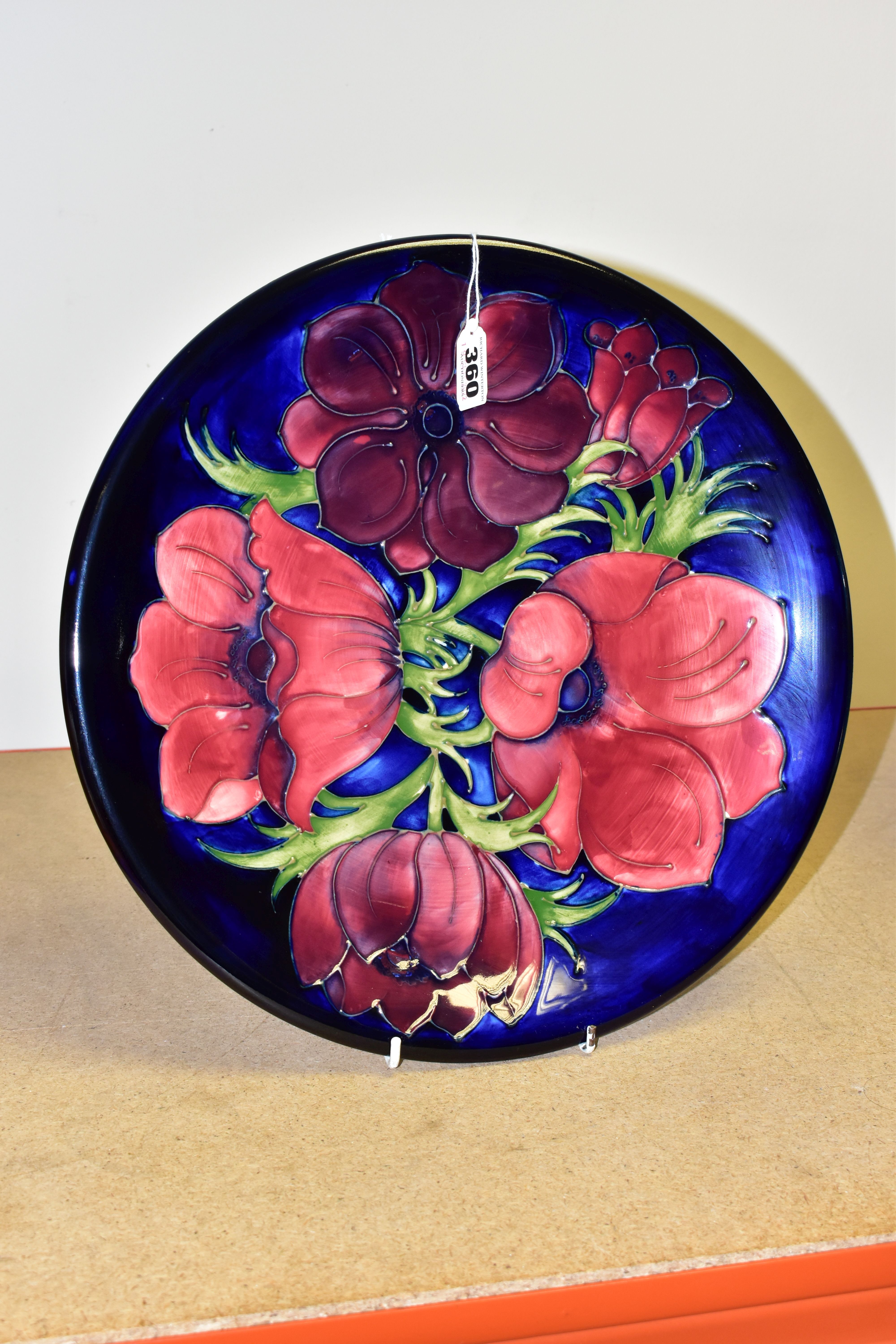 A MOORCROFT POTTERY ANEMONE PATTERN CHARGER, decorated with pink and purple flowers against a cobalt