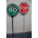 TWO VINTAGE STOP AND GO SIGNS comprising a steel sign and another plastic stop and go sign, along