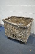 A VINTAGE WICKER MILL BASKET, on four wheels, length 80cm x depth 69cm x height 72cm (condition - in