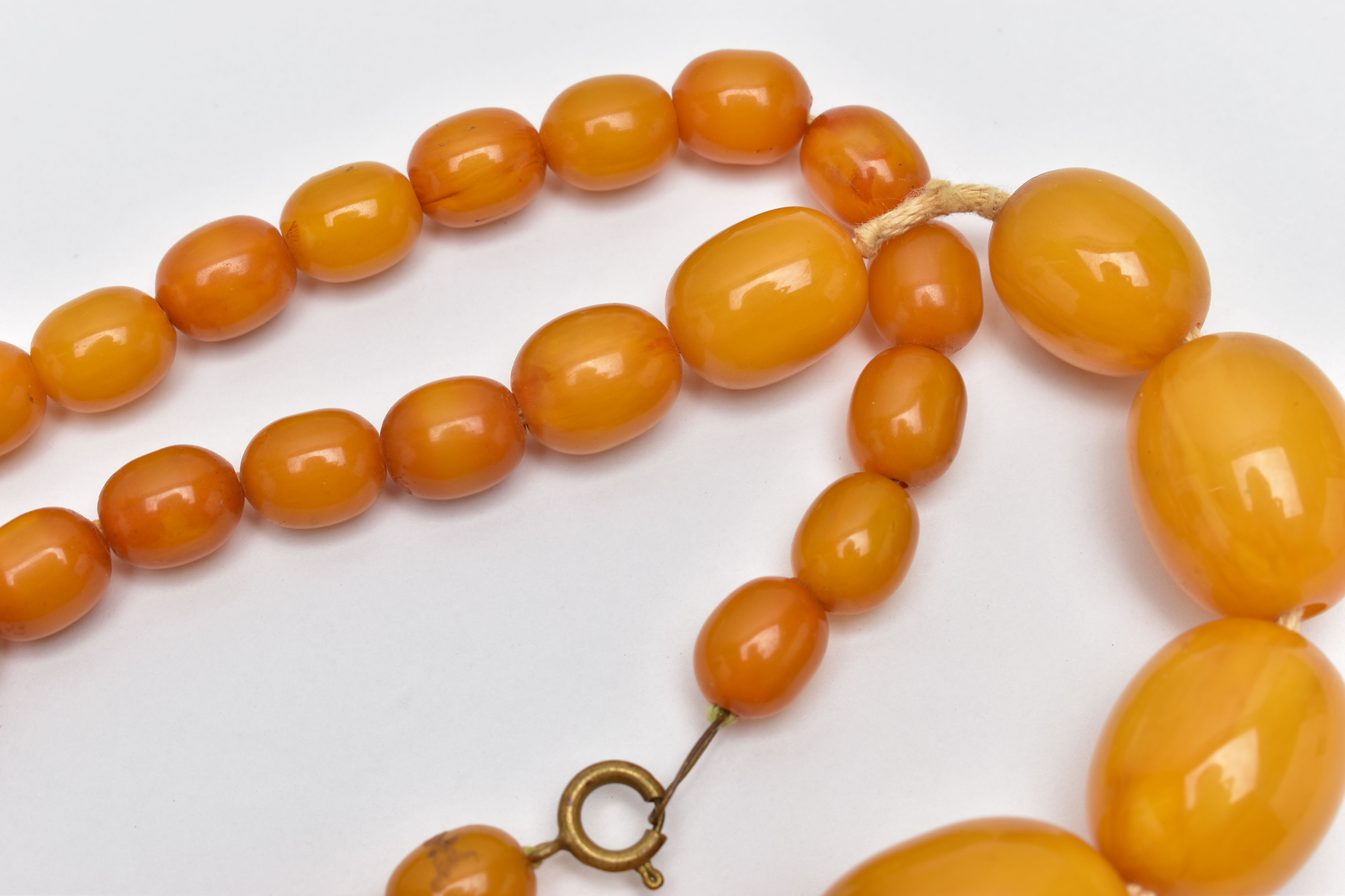 A BAKELITE BEAD NECKLACE, a single row of graduated oval beads, forty one in total, largest - Image 3 of 5