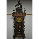 A LATE 19TH CENTURY WALNUT VIENNA WALL CLOCK, with a resin horse pediment, turned pillars to the