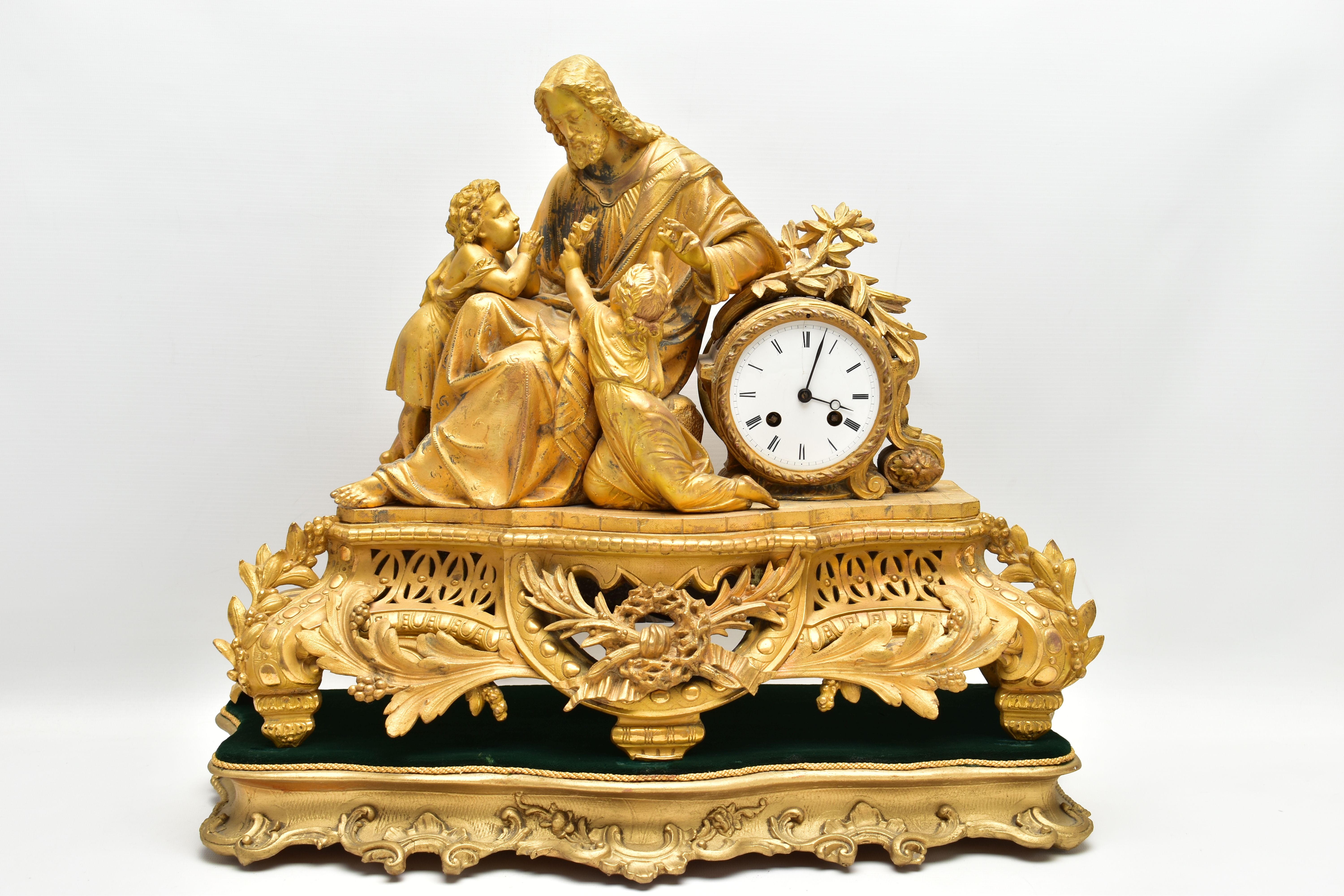 A MID 19TH CENTURY GILT METAL MANTEL CLOCK, cast with a seated figure of Christ and two children,