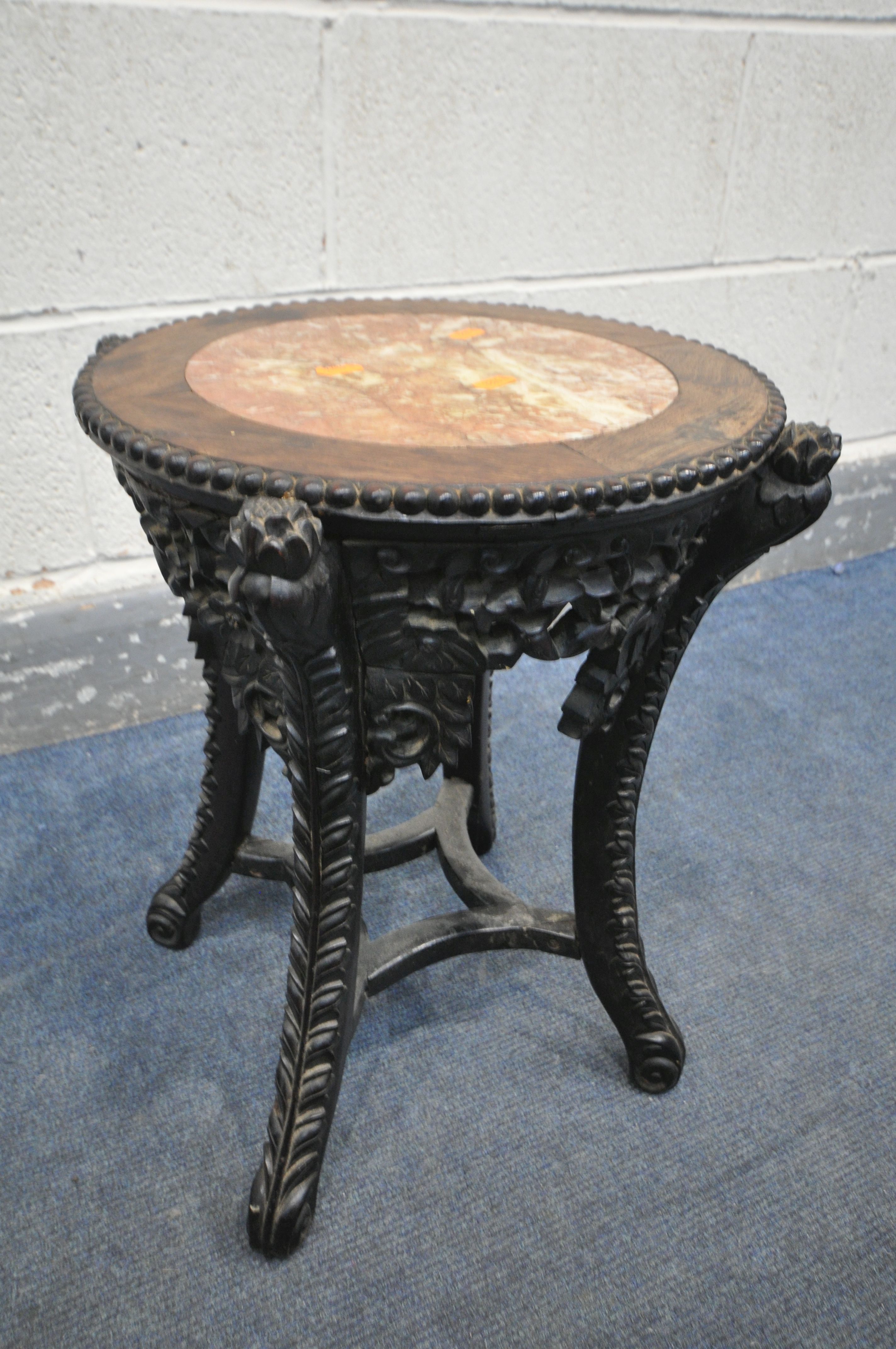 AN INTRICATLY CARVED CIRCULAR CHINESE ROSEWOOD SIDE TABLE, with a veined marble insert, the four