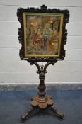 A VICTORIAN ROSEWOOD FIRESCREEN, the shaped foliate frame surrounding needlework scene behind a