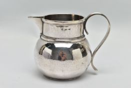 A GEORGE V SILVER JUG OF SQUAT BALUSTER FORM, the S scroll reeded handle on a planished body, makers