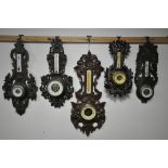 FIVE VARIOUS LATE 19TH/EARLY 20TH CENTURY CARVED WOOD ANEROID BAROMETERS, all unsigned, largest