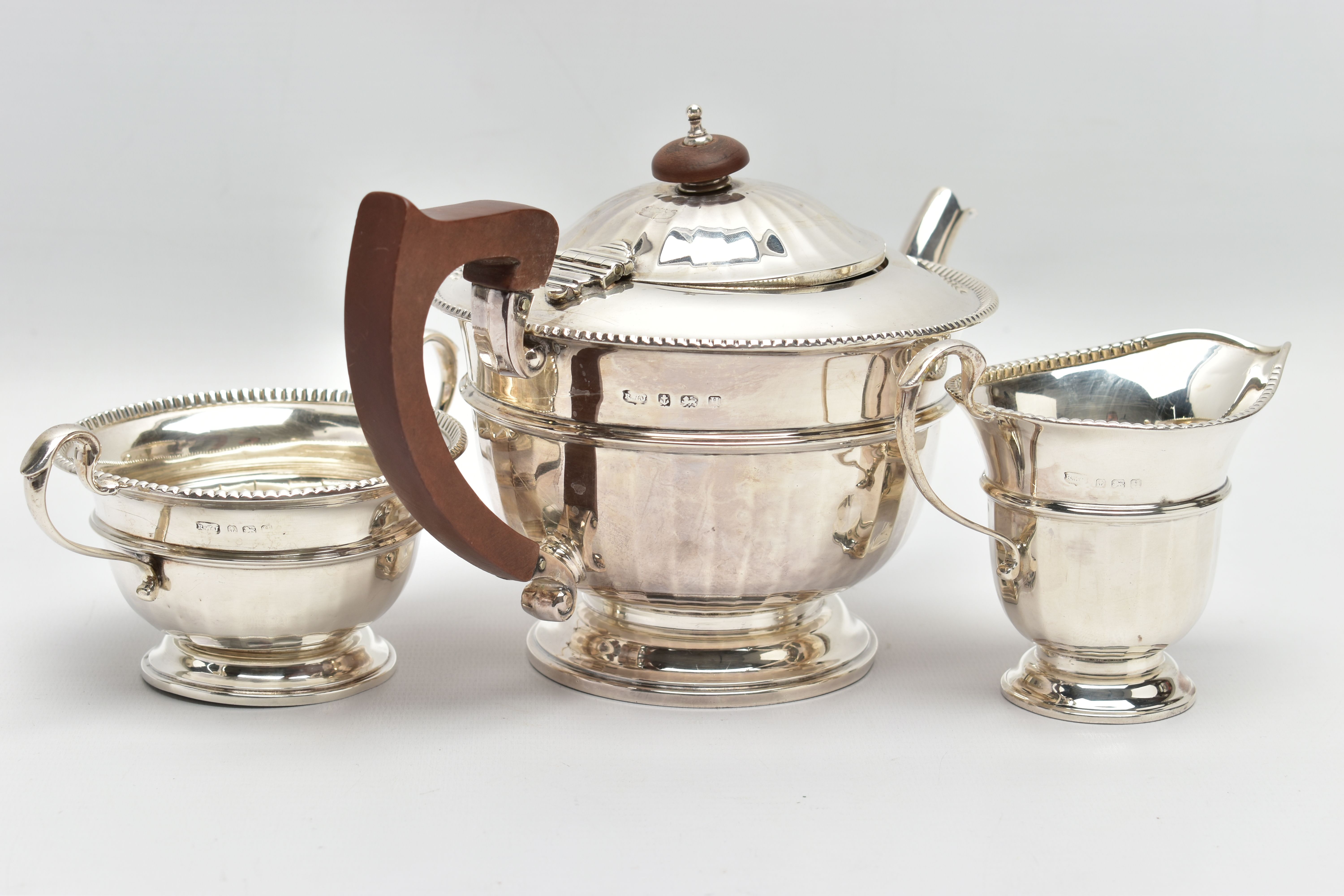 A GEORGE V SILVER THREE PIECE TEA SERVICE OF CIRCULAR PANELLED FORM, reeded rims, S scroll - Image 4 of 9