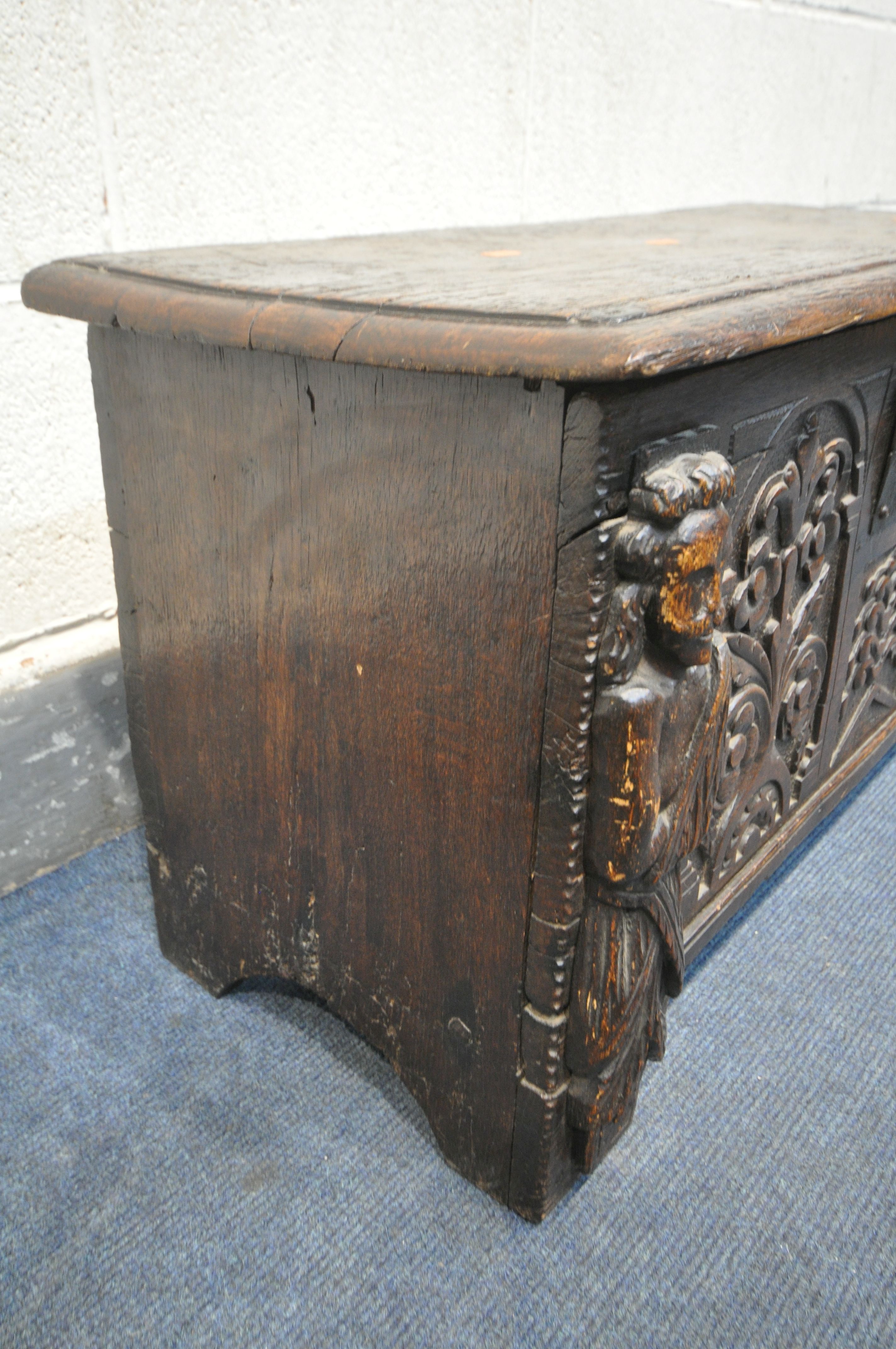 A 17TH CENTURY OAK COFFER, made up of six planks, the carved front with depicting two standing males - Image 4 of 9