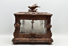 A LATE 19TH CENTURY AND LATER BLACK FOREST CARVED AND STAINED WALNUT TANTALUS, carved surmount of