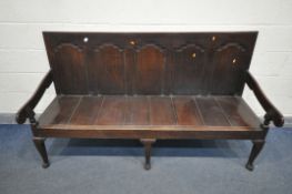 A 18TH CENTURY OAK HALL SETTLE, with five fielded panels, and scrolled open armrests, on triple