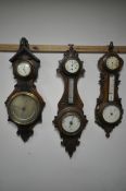 THREE LATE 19TH/EARLY 20TH CENTURY CARVED WOOD BAROMETERS, with clock dials, and two with