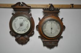 TWO LATE 19TH/EARLY 20TH CENTURY CARVED OAK/WALNUT BAROMETERS, one signed with retailer E Saunders