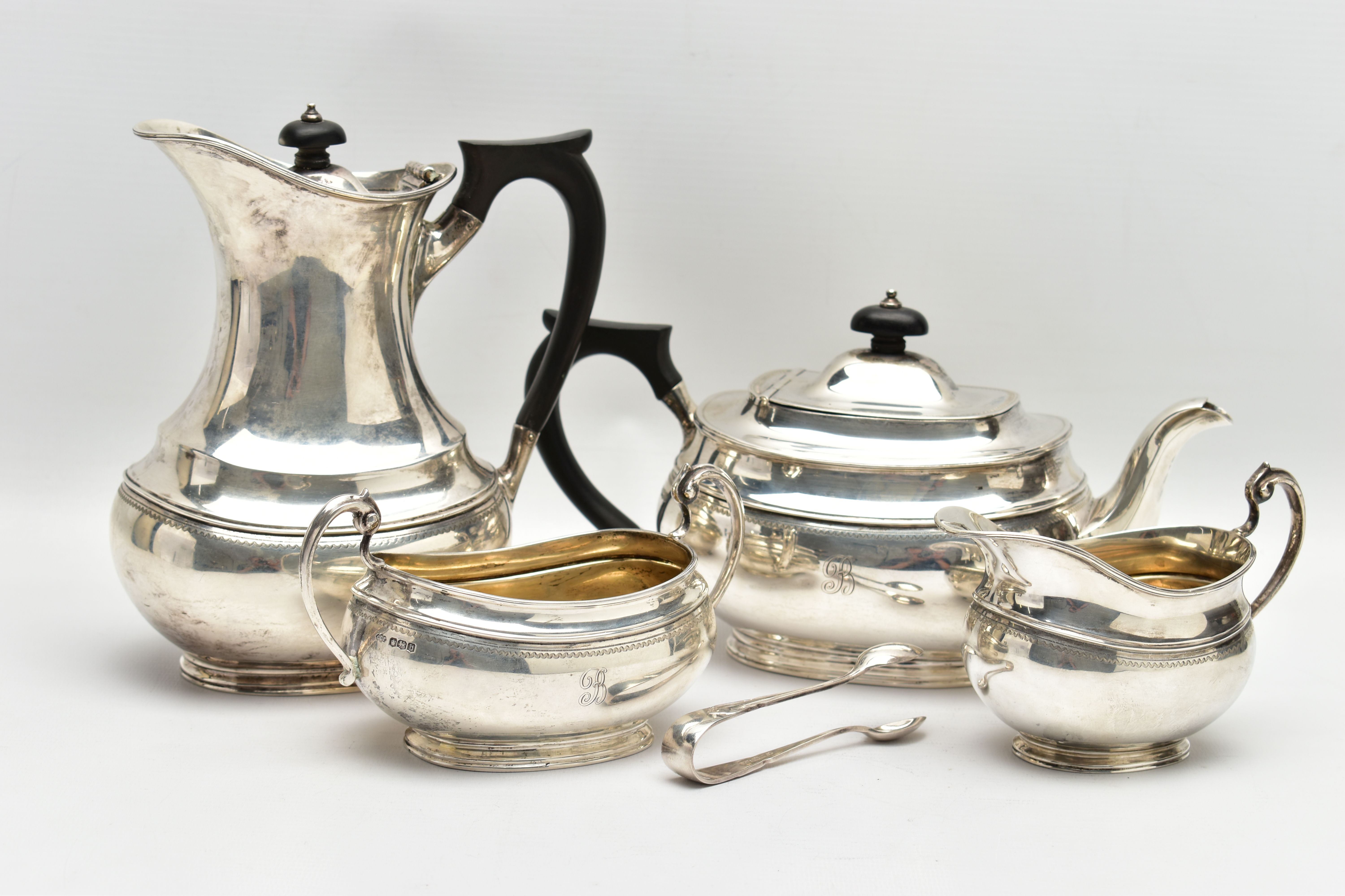 A GEORGE V SILVER FOUR PIECE TEA SERVICE OF OVAL FORM, comprising tea pot, hot water/coffee jug,