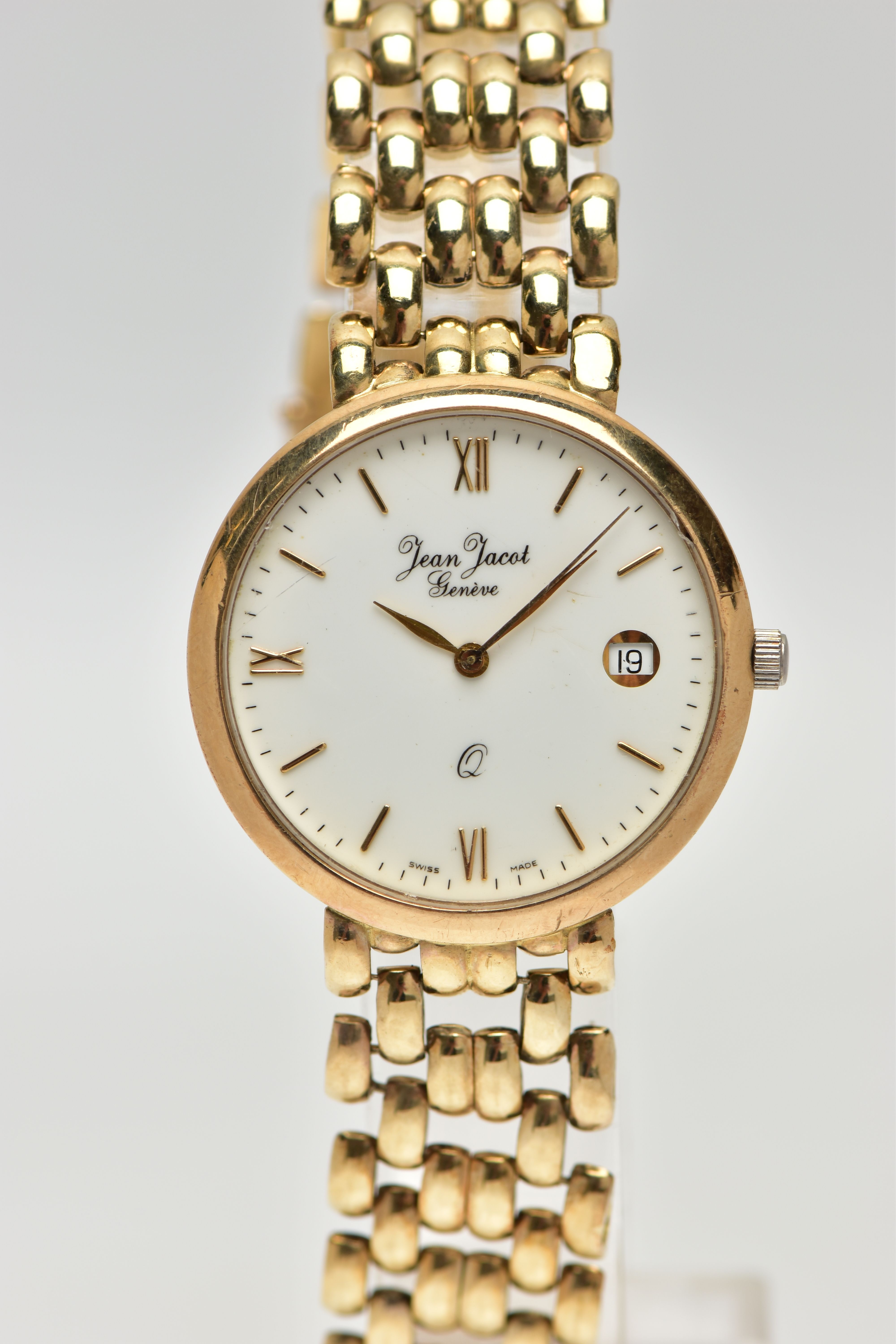 A JEAN JACOT GENEVE YELLOW METAL QUARTZ WRISTWATCH, the white dial with gold tone hourly applied
