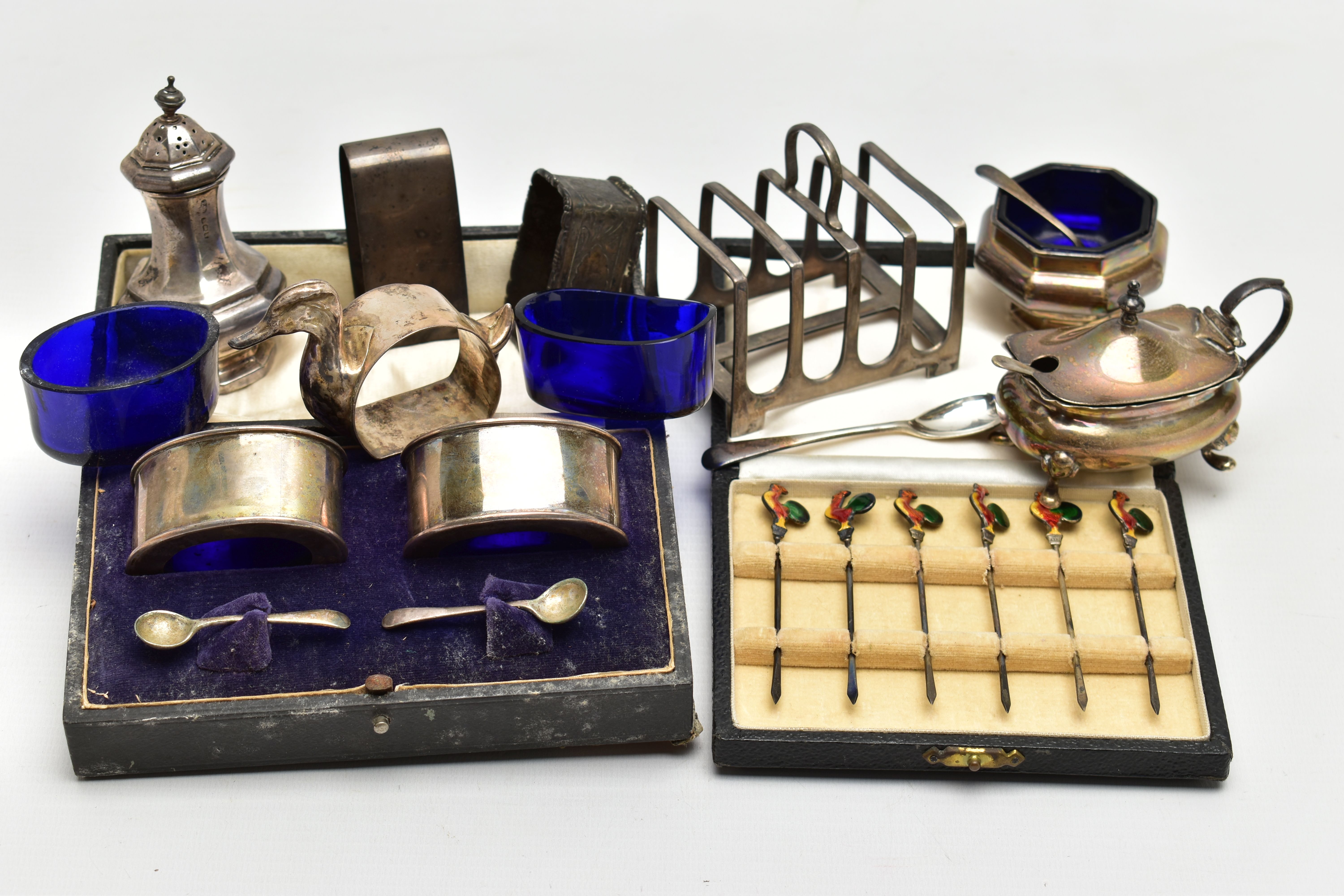 A PARCEL OF SILVER CRUET ITEMS, NAPKIN RINGS, TOAST RACK, ETC, including a cased set of six cocktail