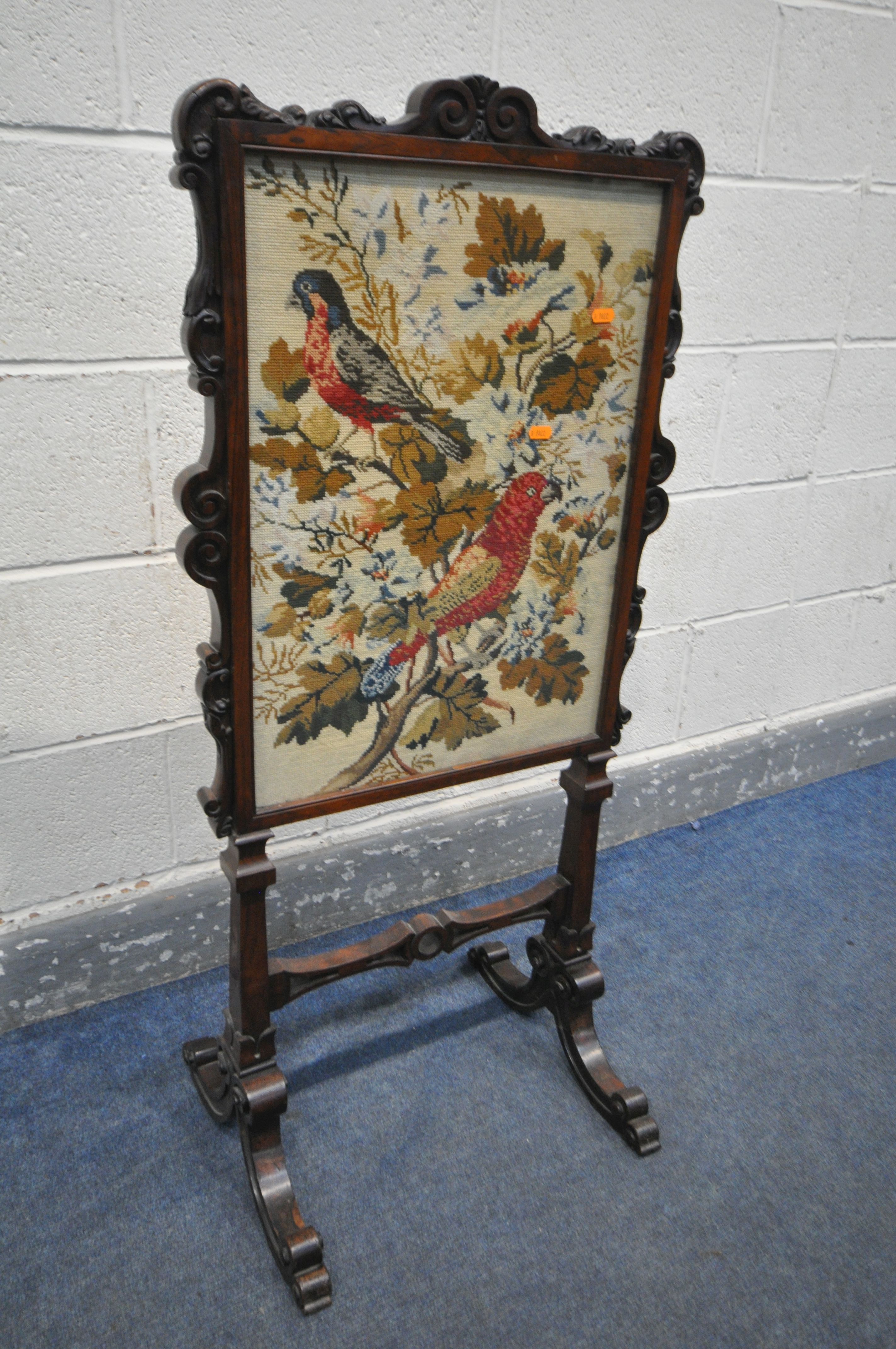 AN EARLY VICTORIAN ROSEWOOD FIRESCREEN, the frame with foliate scrolls, the glass panel enclosing