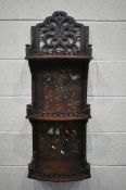 A 20TH CENTURY HARDWOOD JAPANNED WALL SHELF, made up of three shelves, with open foliate fretwork