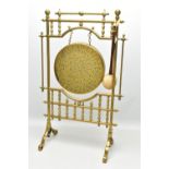 AN EARLY 20TH CENTURY BRASS FLOORSTANDING DINNER GONG, the brass frame with plain and turned