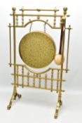 AN EARLY 20TH CENTURY BRASS FLOORSTANDING DINNER GONG, the brass frame with plain and turned