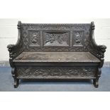 A LATE 19TH CENTURY CARVED OAK JACOBETHAN STYLE HALL SETTLE/BENCH, the two outer panels depicting
