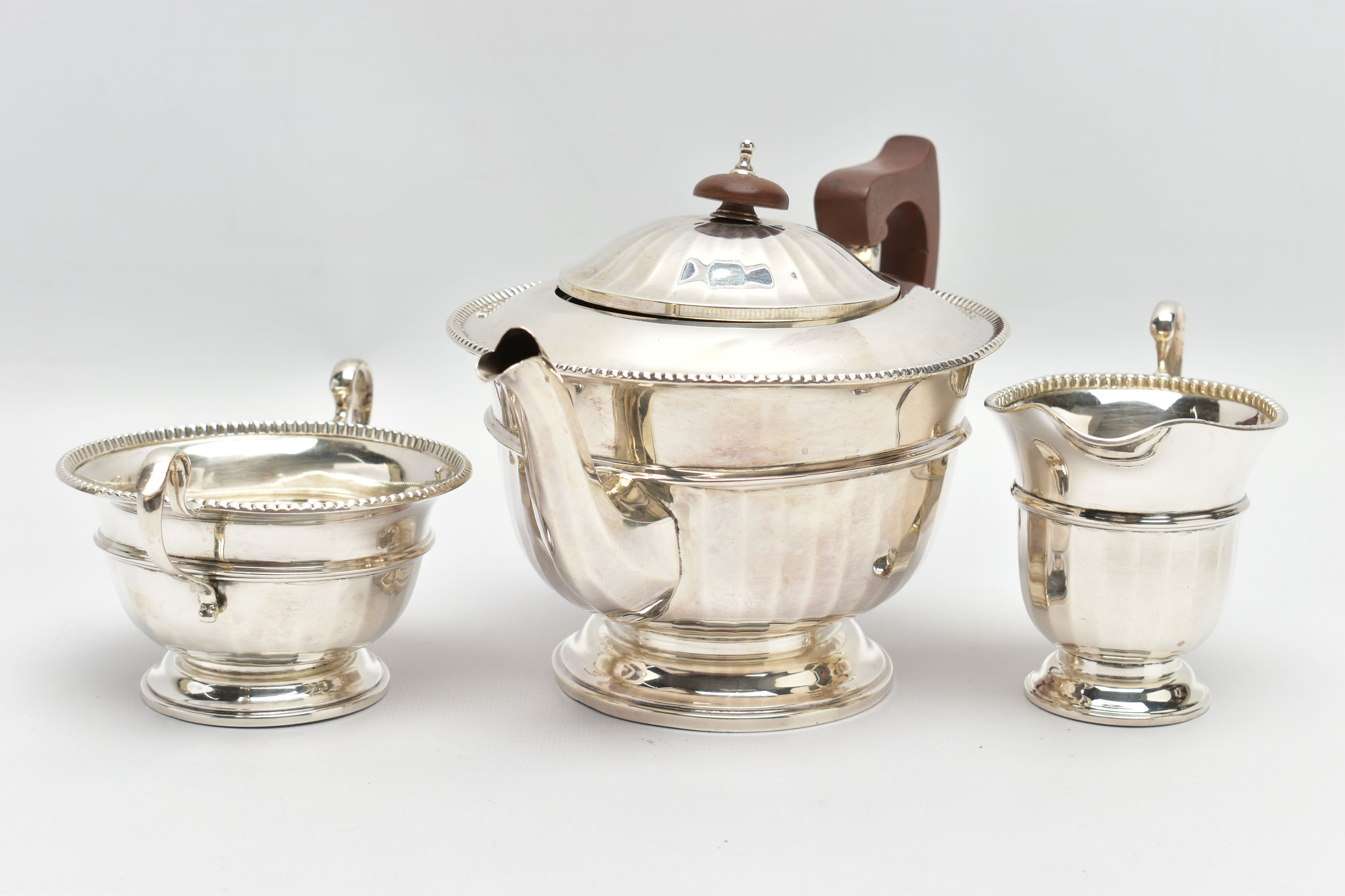 A GEORGE V SILVER THREE PIECE TEA SERVICE OF CIRCULAR PANELLED FORM, reeded rims, S scroll - Image 2 of 9