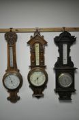 THREE LATE 19TH/EARLY 20TH CENTURY CARVED WOOD ANEROID BAROMETERS, all with thermometers and