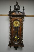 A LATE 19TH CENTURY VIENNA WALL CLOCK, with a resin horse pediment, turned pillars to the doors,