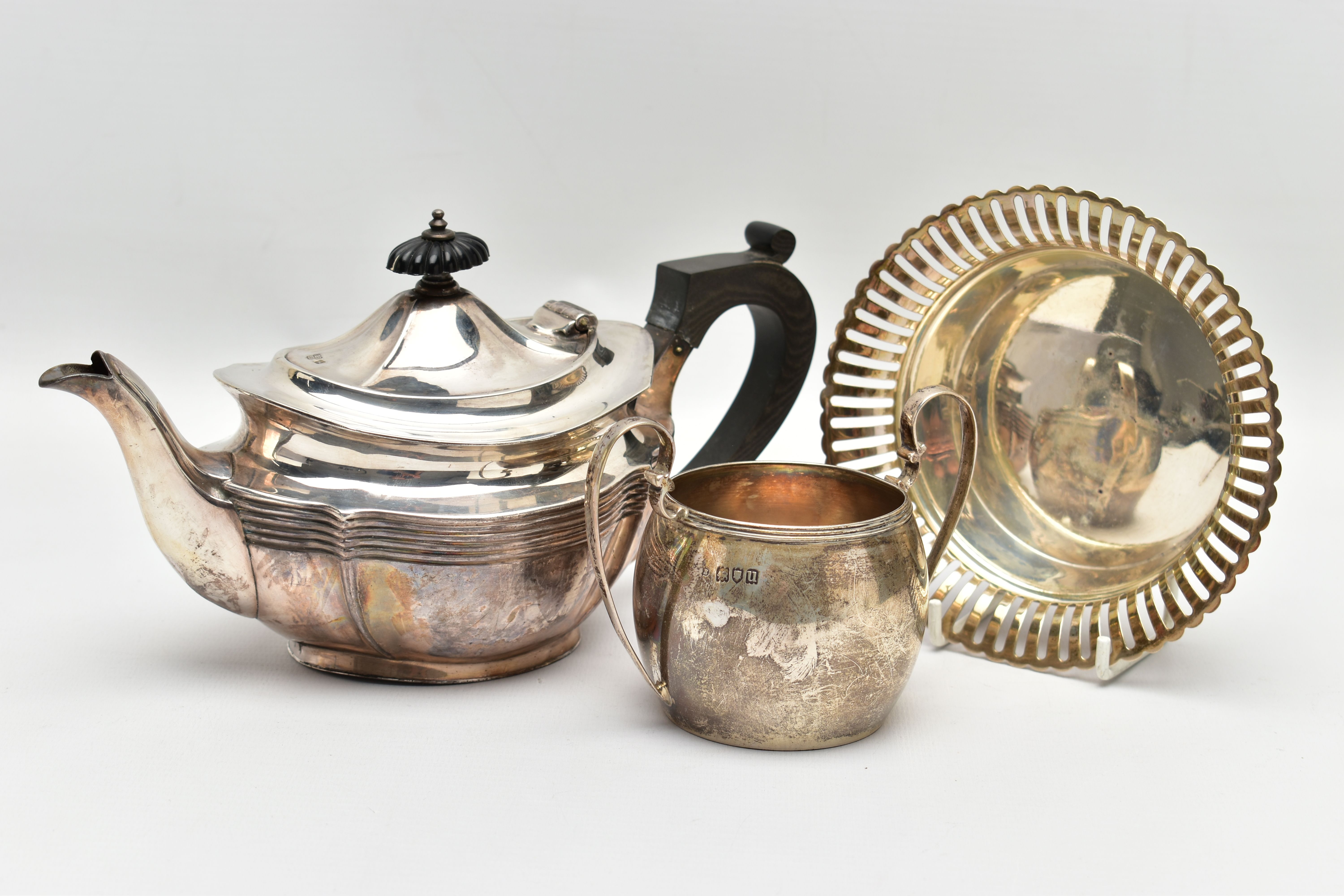 AN EDWARDIAN SILVER BACHELOR'S TEA POT OF SHAPED OVAL FORM, A TWIN HANDLED SILVER SUGAR BOWL AND A