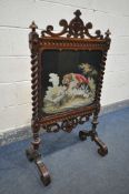 A VICTORIAN WALNUT FIRESCREEN, with open scrolls and central shield, turned finials, barley twist