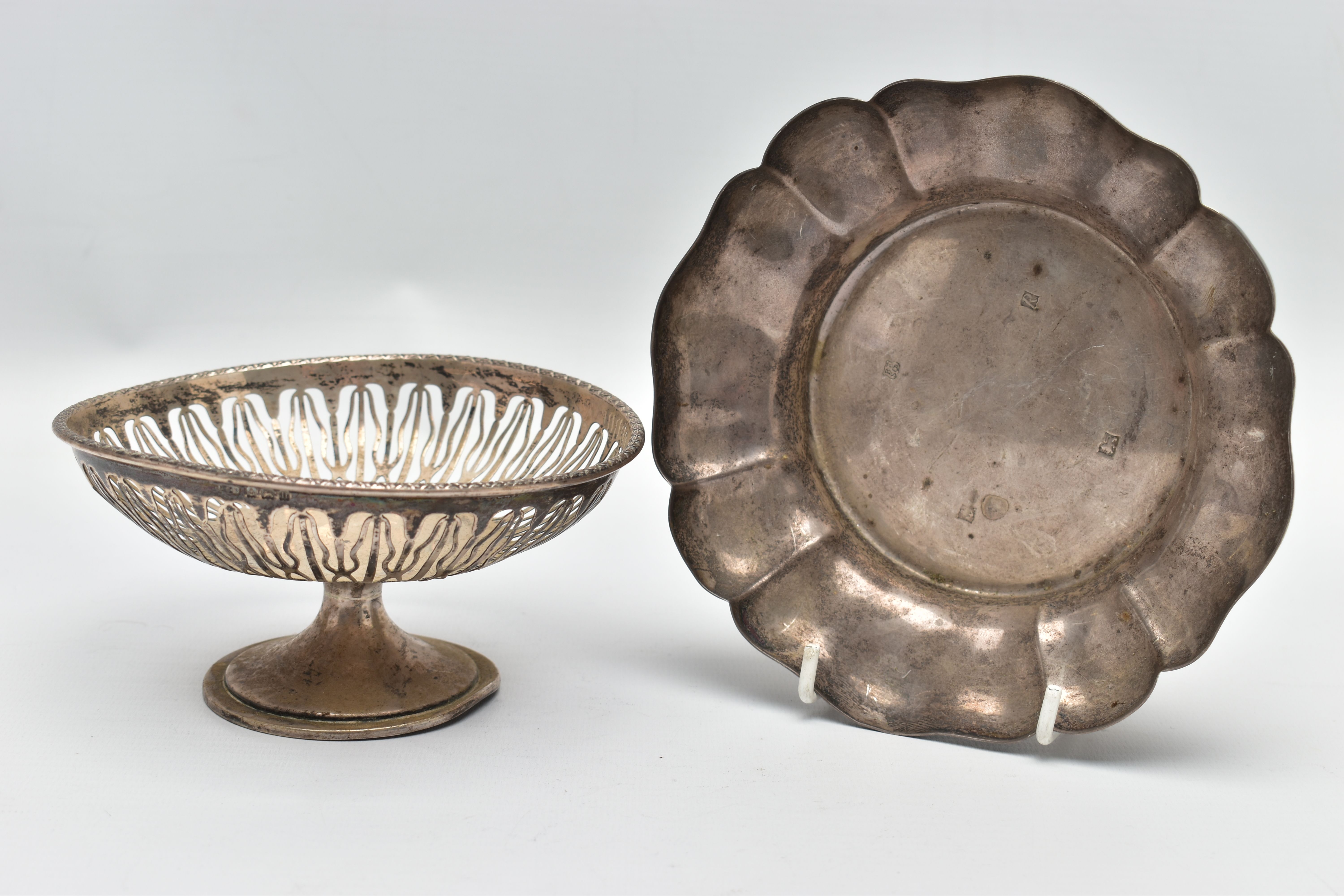 AN ELIZABETH II SILVER DISH OF WAVY OUTLINE AND A GEORGE V PIERCED SILVER PEDESTAL DISH, the wavy