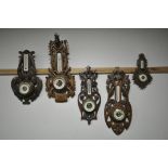 FIVE LATE 19TH/EARLY 20TH CENTURY CARVED WOOD ANEROID BAROMETERS, all unsigned, one with a stags