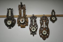 FIVE LATE 19TH/EARLY 20TH CENTURY CARVED WOOD ANEROID BAROMETERS, all unsigned, one with a stags