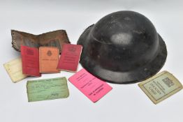 A WWII PERIOD CIVIL DEFENCE HELMET, complete with strap and liner in black plastic/resin, together
