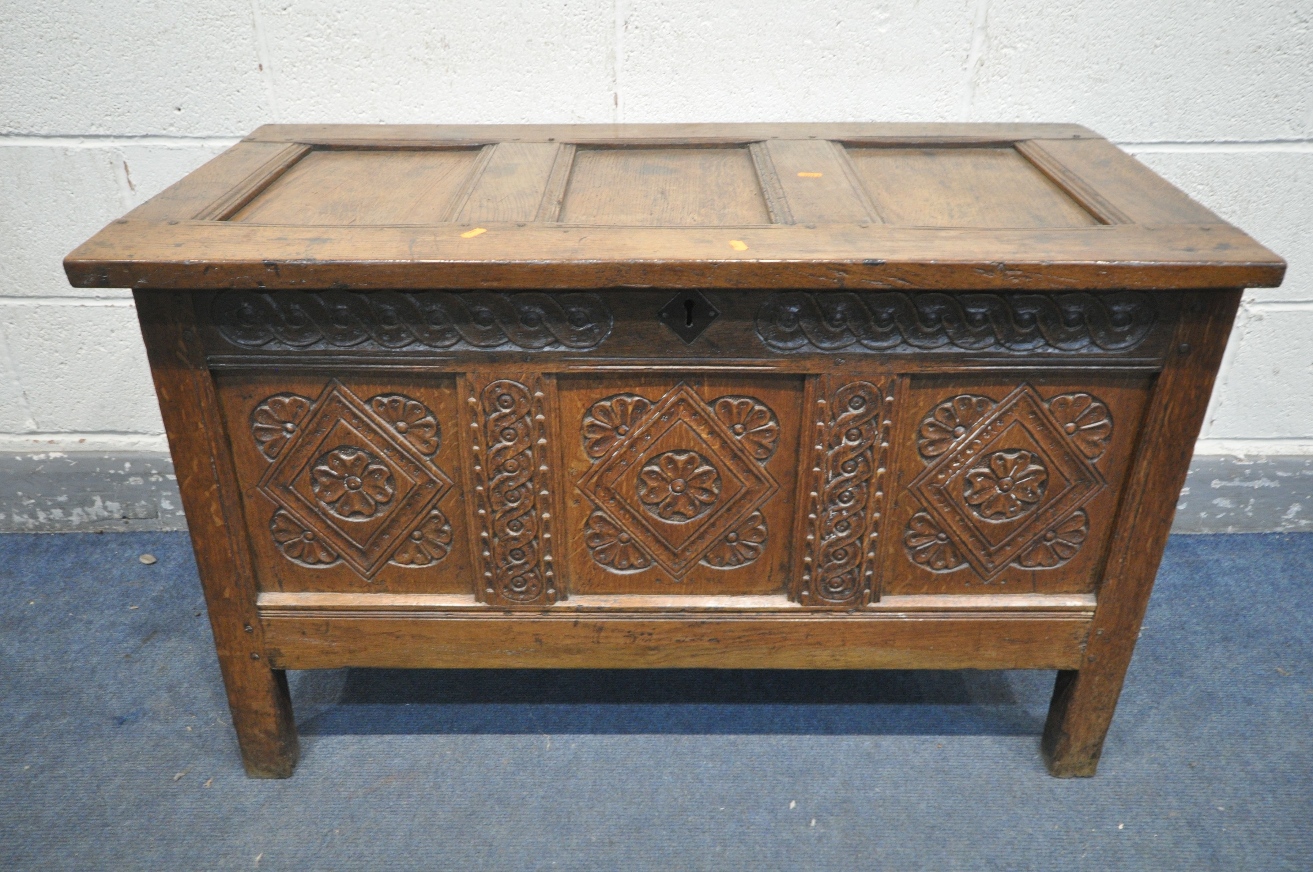 A GEORGIAN OAK COFFER, with a carved panel front, width 105cm x depth 53cm x height 67cm (