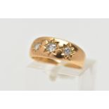 AN 18CT GOLD DIAMOND THREE STONE RING, the graduated old cut diamonds, within a star setting, to the