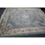 A LARGE RECTANGULAR BLUE GROUND CHINESE WOOLEN RUG, with multistrap border, and foliate decorations,